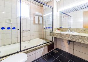 ein Badezimmer mit Badewanne, Waschbecken und Toilette in der Unterkunft Ritter Hotéis - Em frente à Rodoviária de Porto Alegre in Porto Alegre