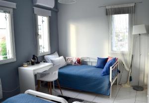 um quarto com uma cama, uma secretária e janelas em Downtown apartment em Kamena Vourla
