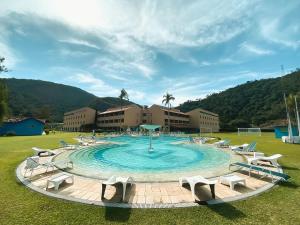una grande piscina con sedie intorno in un campo di Villa Itaipava Resort & Conventions a Itaipava