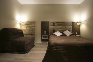 a bedroom with a bed and a chair at Logis Hotel du Col d'Osquich in Musculdy +57 photos
