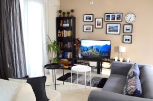 a living room with a couch and a tv at Downtown apartment in Kamena Vourla