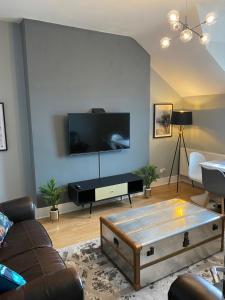 a living room with a couch and a flat screen tv at Aspen House - Apartment 3 in Colwyn Bay