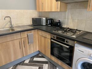 a kitchen with a stove top oven next to a sink at Aspen House - Apartment 3 in Colwyn Bay