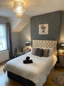 a bedroom with a large white bed with a large headboard at Aspen House - Apartment 3 in Colwyn Bay