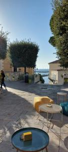 a patio with two tables and a yellow couch at B&B New Acropolis in Agropoli