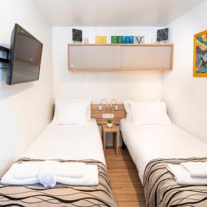 two twin beds in a room with a tv at Mobile Home JOY Porton Biondi in Rovinj