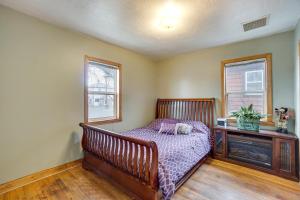 a bedroom with a wooden bed and two windows at Pet-Friendly Torrington Vacation Rental Near River in Torrington