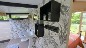 a bathroom with a toilet and a sink on a wall at TAHITI - Cocoon Mataiea B&B in Faremi