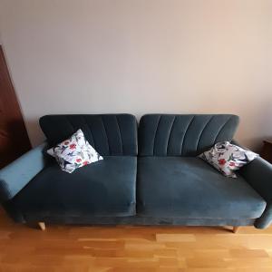 a black leather couch with two pillows on it at Mieszkanie z balkonem in Głuszyca