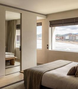 a bedroom with a bed and a large window at Hotel Ur Bare in Zarautz