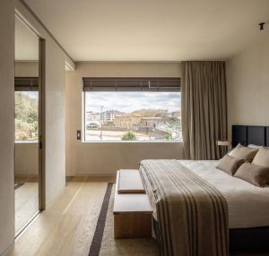 a bedroom with a large bed and a large window at Hotel Ur Bare in Zarautz