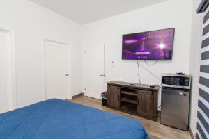 um quarto com uma cama e uma televisão na parede em Residence 4 em Puerto Peñasco