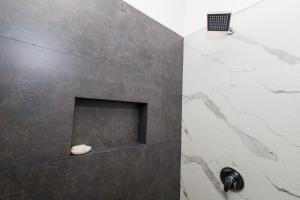 a bathroom with a shower with a stone wall at Residence 4 in Puerto Peñasco