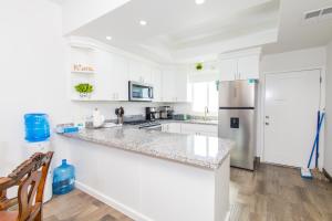 a white kitchen with white cabinets and a refrigerator at Residence 4 in Puerto Peñasco