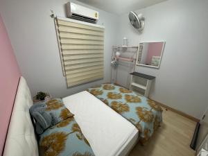 Dormitorio pequeño con cama y espejo en S Villa @Impact Muangthongthani en Pak Kret