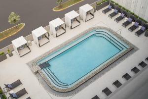 an overhead view of a swimming pool with lounge chairs and a swimming pool at AC Hotel by Marriott Miami Dadeland in Miami