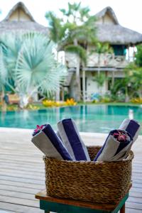 a basket filled withogie boards on a table next to a pool at Ventura Barra Grande in Barra Grande