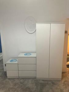 a white cabinet with two drawers and a plate on the wall at The New Apollo Hotel in Blackpool