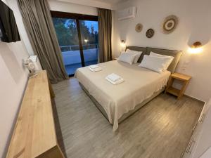 ein Schlafzimmer mit einem Bett mit zwei Handtüchern darauf in der Unterkunft Golden Evelyn in Agia Paraskevi