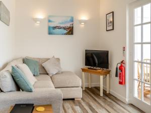 sala de estar con sofá y TV de pantalla plana en Uk43574 - Fern Cottage, en Begelly