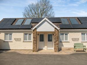 una casa con paneles solares encima en Uk43574 - Fern Cottage, en Begelly