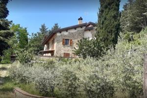 a stone house in the middle of a garden at Ca'de Picchio in Arezzo