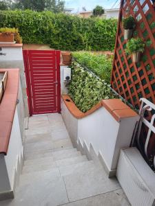 klatka schodowa z czerwonymi drzwiami w ogrodzie w obiekcie Casa sul Mare Formia Con una Splendida Terrazza w mieście Formia
