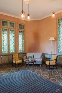 - un salon avec un canapé, des chaises et des vitraux dans l'établissement Gîte du parc à Langel, à Armissan
