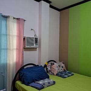 a bedroom with a bed and a air conditioner on the wall at JZA Transient House in Cagayan de Oro