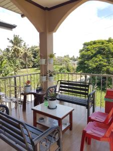 une terrasse couverte avec des chaises, des tables et une clôture dans l'établissement JZA Transient House, à Cagayán de Oro