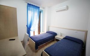 a hotel room with two beds and a window at B&B New Acropolis in Agropoli