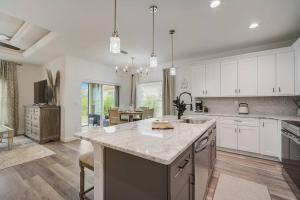 a large kitchen with white cabinets and a large island at South West Florida Family Home, 3 Bedroom,2 Bathroom, King bed suite, Close to Beaches, Parks, Fishing, Golfing, Kayaking in Rotonda West