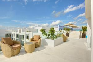 un patio con sillas y plantas en un edificio en Anah Suites by Las Flores, en Playa del Carmen