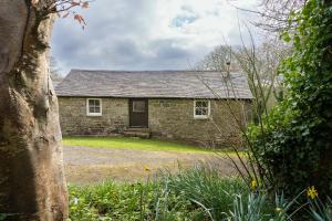 una antigua casa de piedra con un patio en Beautiful Cornish barn in the stunning Lamorna valley with large garden, en Paul