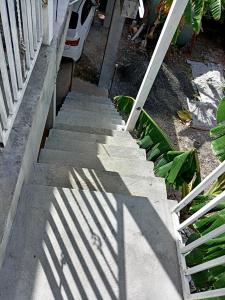 una escalera con una sombra de una valla en ella en Habitación privada a 8 minutos del Aeropuerto Tocumen en Tapia Número Dos