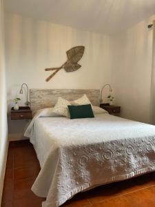 a bedroom with a large bed with a broom on the wall at La Casita de la Breña. in Frontera