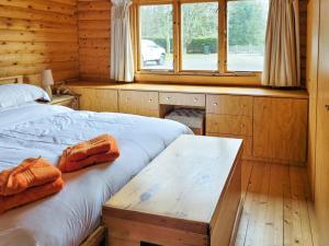 a bedroom with two beds and a table in it at Ardle Lodge in Enochdhu