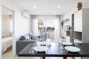 a living room with a dining table and a couch at Playa-Piscina-Port Aventura4 in Salou