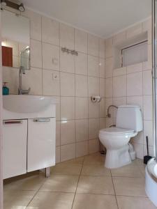 Łazienka z białą toaletą i umywalką w obiekcie Słoneczne Apartamenty w mieście Mielno
