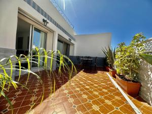 une terrasse avec des plantes en pot sur une maison dans l'établissement La Terrasse de l'agdal, à Rabat