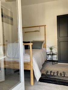 sypialnia z łóżkiem z drewnianą ramą w obiekcie AUX 4 LOGIS Appart-hotel - Studio Le Roof - Une vue splendide - Petit déjeuner inclus 1ère nuit w mieście Foix