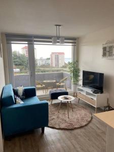 a living room with a blue couch and a table at Departamento a minutos del centro de Puerto Montt Pelluco alto in Puerto Montt