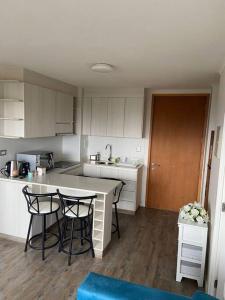 a kitchen with white cabinets and a table and chairs at Departamento a minutos del centro de Puerto Montt Pelluco alto in Puerto Montt