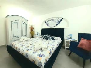 een slaapkamer met een bed en een blauwe stoel bij B&B Dal Duca Enrico in Castelsardo