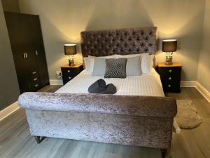 a bedroom with a large bed with a large headboard at Aspen House - Apartment 1 in Colwyn Bay