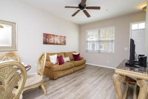 ein Wohnzimmer mit einem Sofa und einem Deckenventilator in der Unterkunft Charming 3-Bedroom Villa in Gated Community - Your Perfect Getaway! in Kissimmee