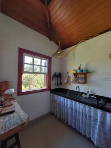 uma cozinha com um lavatório e uma janela em Chalés Vila das Cachoeiras em Diamantina