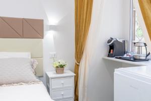 ein weißes Schlafzimmer mit einem Bett und einem Fenster in der Unterkunft Glint House Roma in Rom