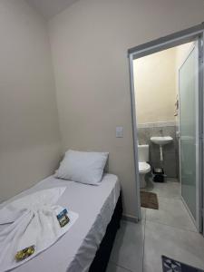 a small bedroom with a bed and a bathroom at Apartamento Aconchegante in Brotas