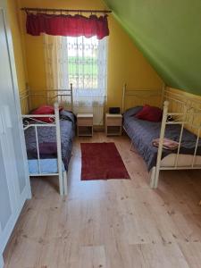a bedroom with two bunk beds and a window at Gospodarstwo Agroturystyczne Ćmilówka 